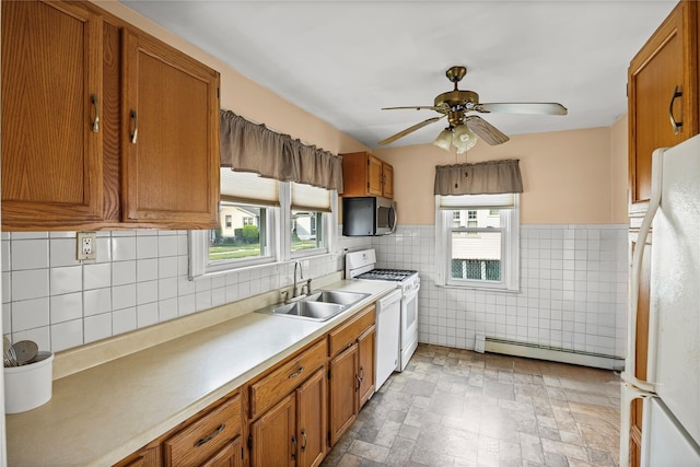 178 Charles St, Lynbrook, NY 11563 - kitchen with white appliances, a baseboard heating unit, brown cabinets, plenty of natural light, and tile walls