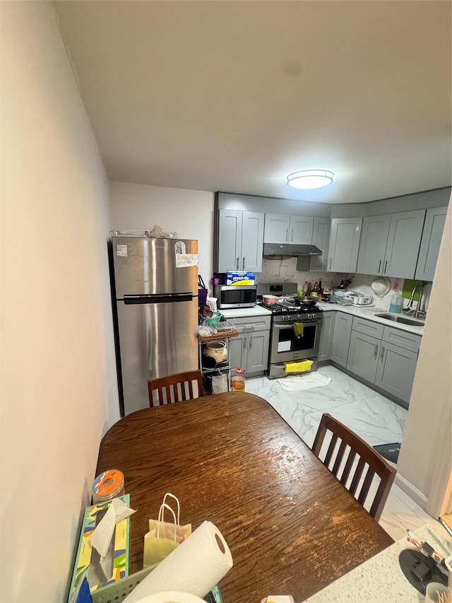 8114 Baxter Ave Unit 1E, Elmhurst, NY 11373 - kitchen with appliances with stainless steel finishes, light marble finish flooring, under cabinet range hood, gray cabinetry, and light countertops