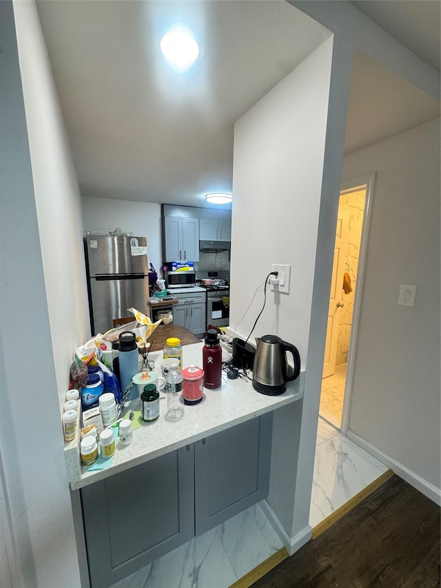 8114 Baxter Ave Unit 1E, Elmhurst, NY 11373 - kitchen with stainless steel appliances, light marble finish flooring, a peninsula, and under cabinet range hood