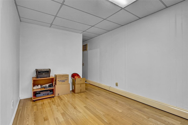 56-28 213th St, Bayside, NY 11364 - spare room featuring a drop ceiling, a baseboard heating unit, and light wood-style floors