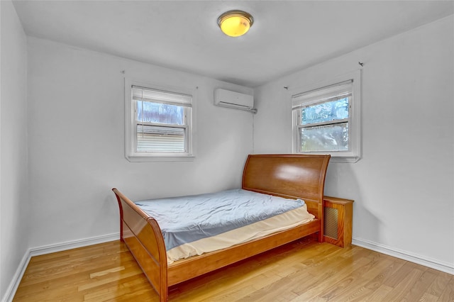 56-28 213th St, Bayside, NY 11364 - bedroom featuring a wall mounted AC, wood finished floors, and multiple windows