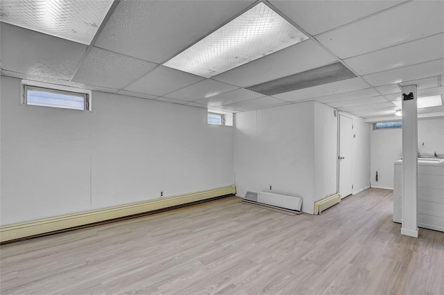 56-28 213th St, Bayside, NY 11364 - basement with washer / clothes dryer, healthy amount of natural light, light wood-type flooring, a baseboard radiator, and a drop ceiling