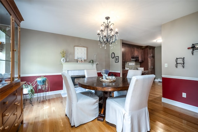 48 Devon Rd, Patterson, NY 12563 - dining space with light wood-style floors, a chandelier, and a premium fireplace