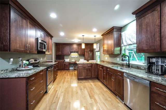 48 Devon Rd, Patterson, NY 12563 - kitchen featuring stainless steel appliances, light wood-type flooring, a peninsula, hanging light fixtures, and stone counters