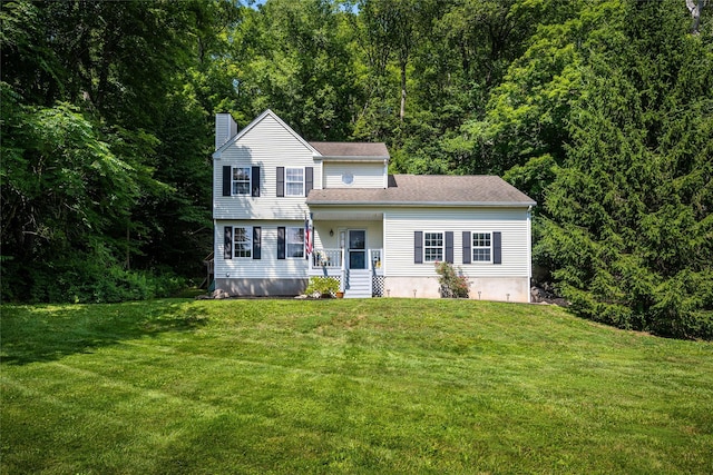 48 Devon Rd, Patterson, NY 12563 - view of front facade featuring a chimney, a front yard, and a wooded view