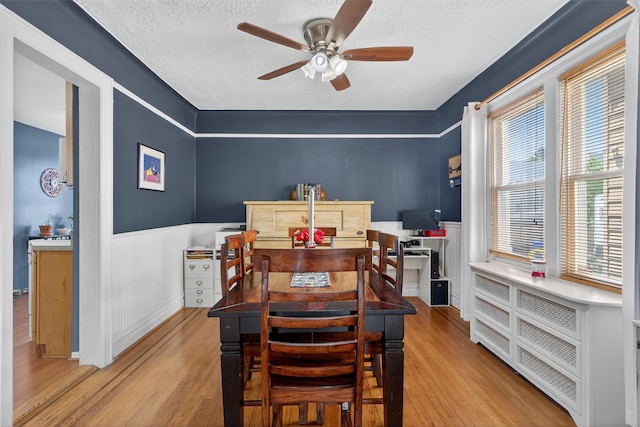 829 Logan Ave, Bronx, NY 10465 - dining room with wainscoting, wood finished floors, a ceiling fan, and a textured ceiling