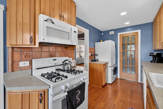 829 Logan Ave, Bronx, NY 10465 - kitchen featuring white appliances, wood finished floors, backsplash, light countertops, and recessed lighting