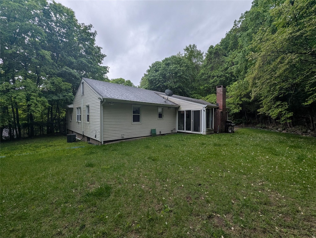 6 Oak Pl, Tuxedo Park, NY 10987 - back of house featuring a chimney, a yard, a sunroom, and roof with shingles