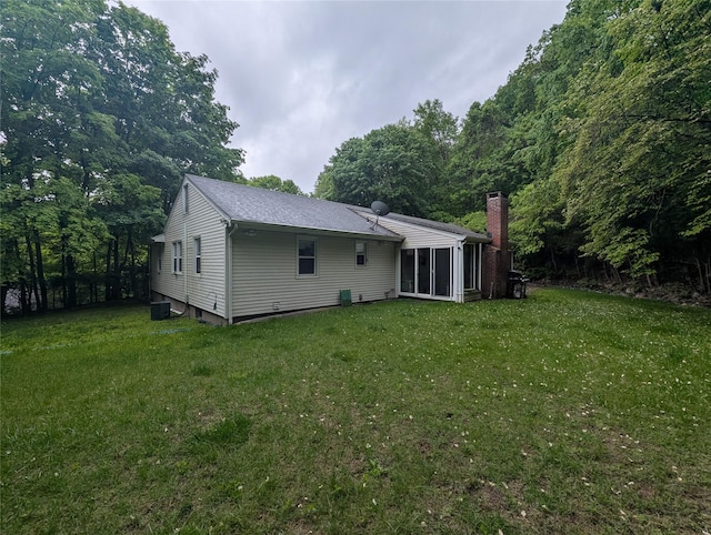 6 Oak Pl, Tuxedo Park, NY 10987 - back of house featuring a chimney, a yard, a sunroom, and roof with shingles