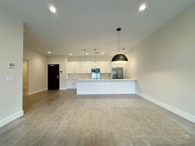 30 Beekman St Unit Ph3, Beacon, NY 12508 - kitchen featuring stainless steel appliances, open floor plan, white cabinets, recessed lighting, and hanging light fixtures