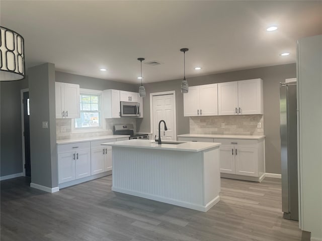 882 Union Blvd, West Islip, NY 11795 - kitchen featuring appliances with stainless steel finishes, white cabinets, wood finished floors, backsplash, and recessed lighting