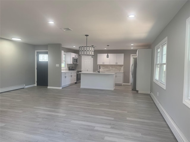 882 Union Blvd, West Islip, NY 11795 - kitchen with stainless steel appliances, open floor plan, recessed lighting, light countertops, and light wood finished floors