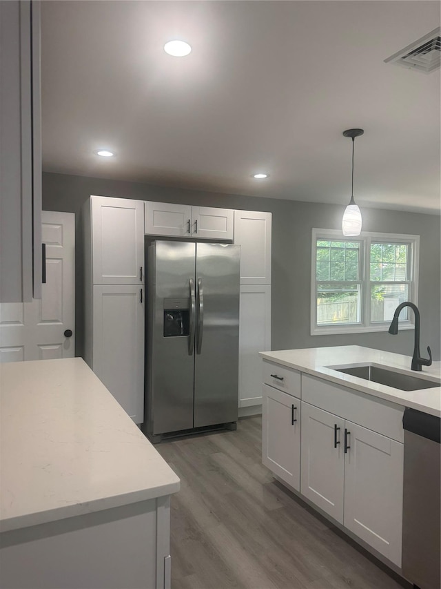 882 Union Blvd, West Islip, NY 11795 - kitchen featuring appliances with stainless steel finishes, light countertops, wood finished floors, white cabinetry, and recessed lighting
