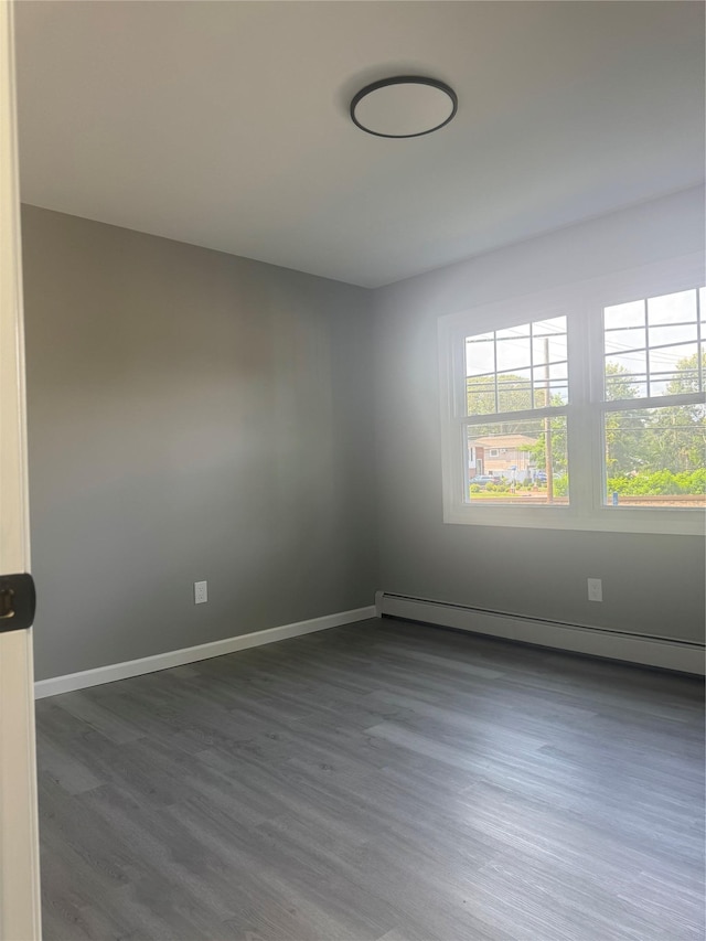 882 Union Blvd, West Islip, NY 11795 - spare room featuring a baseboard heating unit and dark wood-type flooring