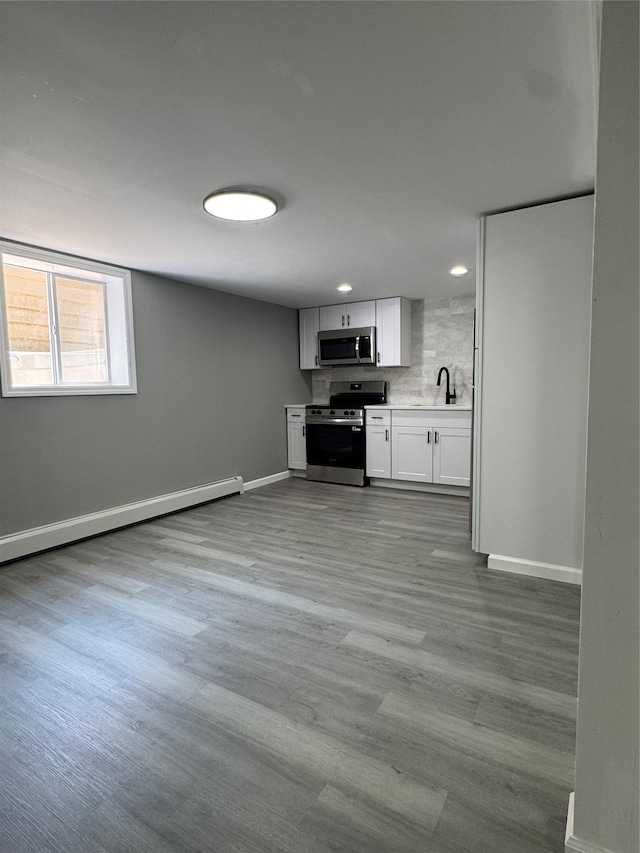882 Union Blvd, West Islip, NY 11795 - kitchen featuring stainless steel appliances, recessed lighting, light countertops, wood finished floors, and white cabinetry