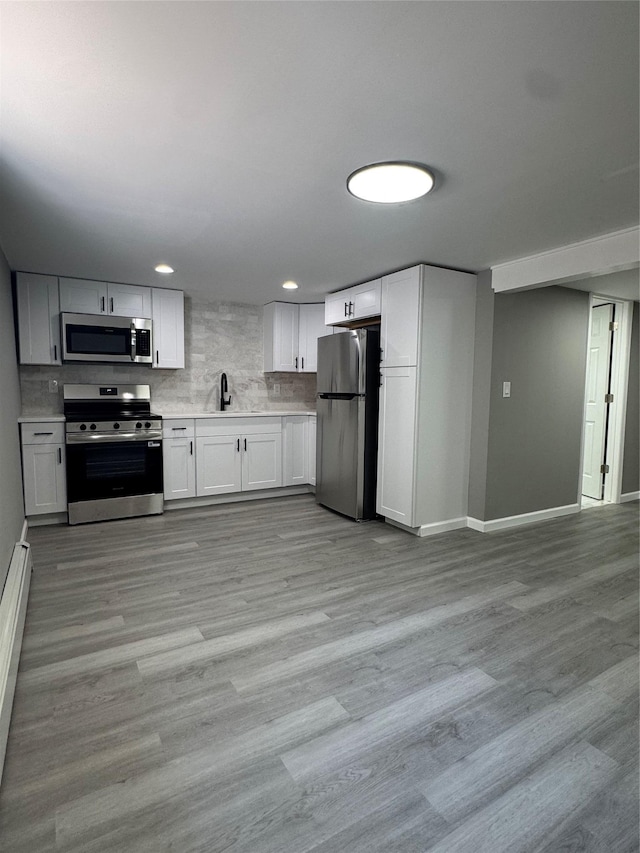 882 Union Blvd, West Islip, NY 11795 - kitchen with appliances with stainless steel finishes, light countertops, recessed lighting, white cabinets, and light wood finished floors