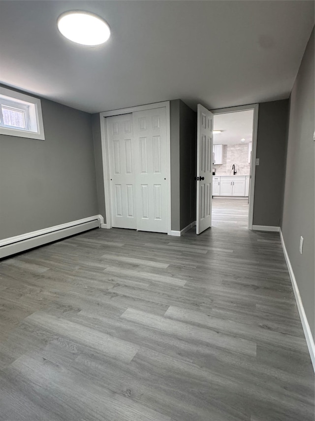 882 Union Blvd, West Islip, NY 11795 - unfurnished bedroom with wood finished floors, a closet, and a baseboard heating unit