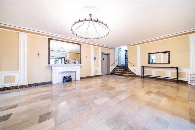4037 77th St Unit 5B, Elmhurst, NY 11373 - unfurnished living room with a chandelier, stairs, a decorative wall, ornamental molding, and a wainscoted wall