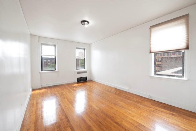 4037 77th St Unit 5B, Elmhurst, NY 11373 - unfurnished room with radiator heating unit and wood finished floors