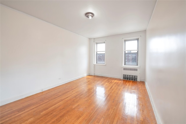4037 77th St Unit 5B, Elmhurst, NY 11373 - empty room with radiator heating unit and light wood-style floors