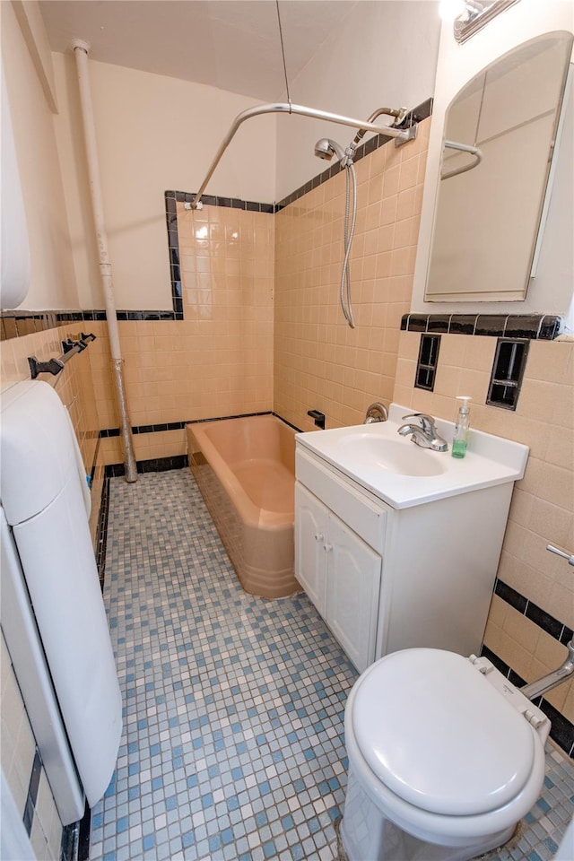 4037 77th St Unit 5B, Elmhurst, NY 11373 - bathroom featuring tile walls, washtub / shower combination, vanity, tile patterned flooring, and wainscoting