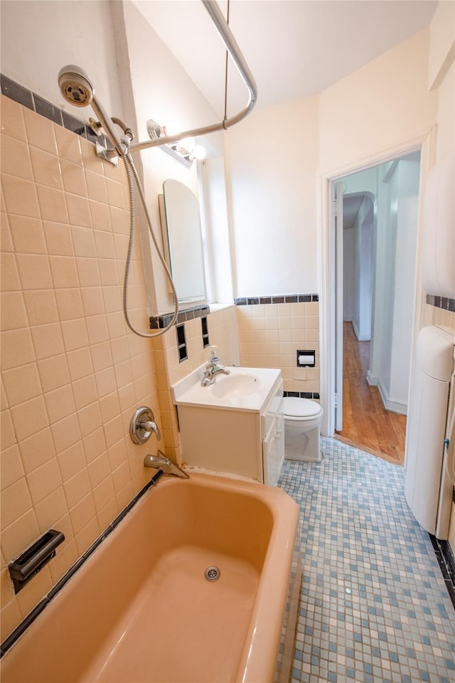 4037 77th St Unit 5B, Elmhurst, NY 11373 - bathroom with tile walls, tile patterned floors, vanity, bathtub / shower combination, and a wainscoted wall