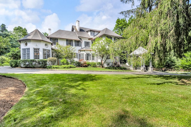 77 Haights Cross Rd, Chappaqua, NY 10514 - rear view of house featuring a yard, a chimney, and stucco siding