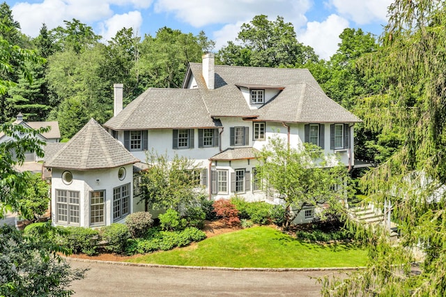77 Haights Cross Rd, Chappaqua, NY 10514 - view of front of property with a chimney, stucco siding, a front yard, and roof with shingles