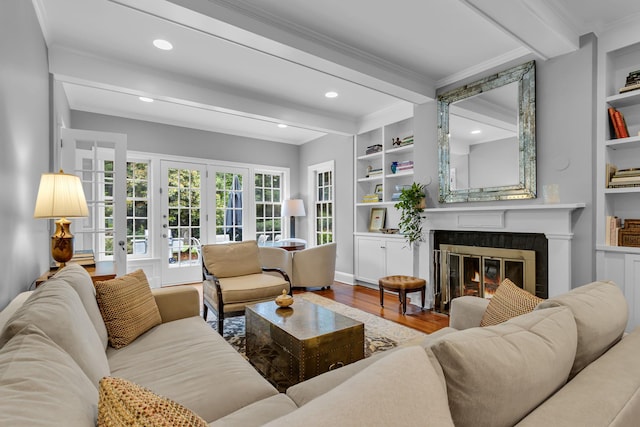 77 Haights Cross Rd, Chappaqua, NY 10514 - living room with beam ceiling, a glass covered fireplace, ornamental molding, wood finished floors, and built in features