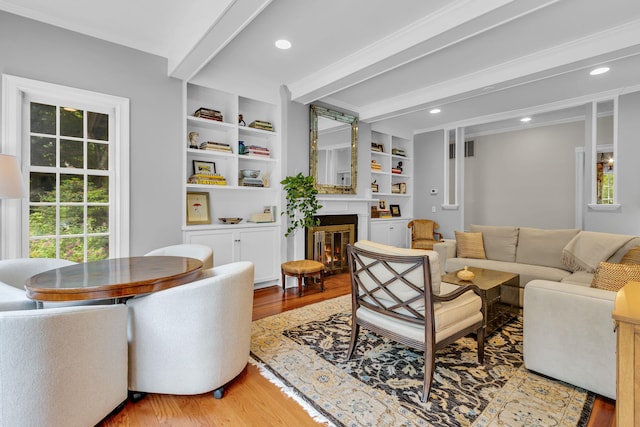 77 Haights Cross Rd, Chappaqua, NY 10514 - living room featuring light wood finished floors, a glass covered fireplace, plenty of natural light, beamed ceiling, and recessed lighting