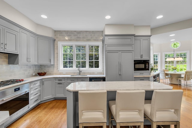 77 Haights Cross Rd, Chappaqua, NY 10514 - kitchen featuring gray cabinets, black appliances, a breakfast bar, plenty of natural light, and recessed lighting