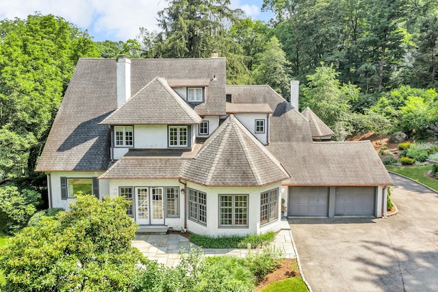 77 Haights Cross Rd, Chappaqua, NY 10514 - shingle-style home with a chimney, stucco siding, driveway, a garage, and a shingled roof