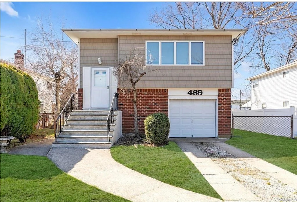 469 N Newbridge Rd, Levittown, NY 11756 - view of front of house featuring brick siding, a garage, and concrete driveway