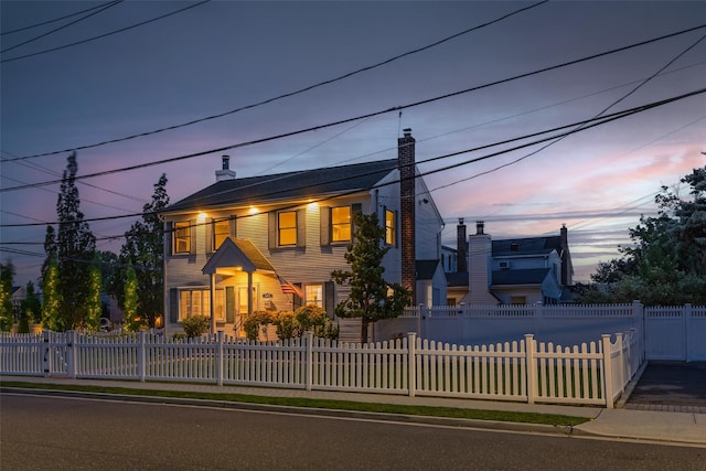 1859 George Ct, Merrick, NY 11566 - view of front facade featuring a chimney and a fenced front yard