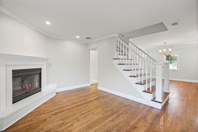 1859 George Ct, Merrick, NY 11566 - unfurnished living room featuring ornamental molding, stairs, wood finished floors, a glass covered fireplace, and a chandelier