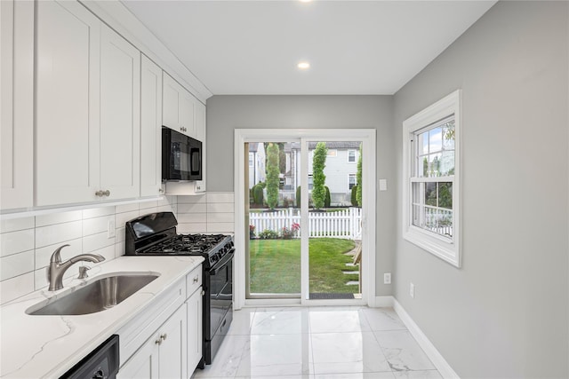1859 George Ct, Merrick, NY 11566 - kitchen featuring black appliances, light marble finish flooring, tasteful backsplash, light stone counters, and recessed lighting