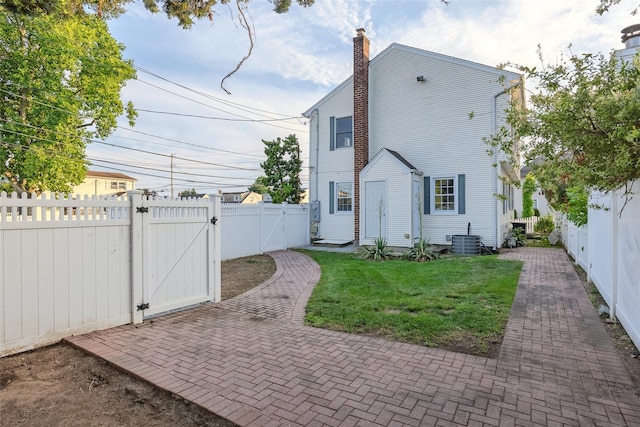 1859 George Ct, Merrick, NY 11566 - rear view of property with a gate, a fenced backyard, a patio area, and a chimney