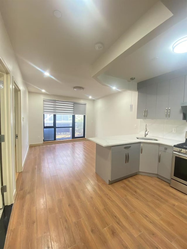 42-22 Crescent St Unit 3B, Long Island City, NY 11101 - kitchen with gas range, open floor plan, a peninsula, and light countertops