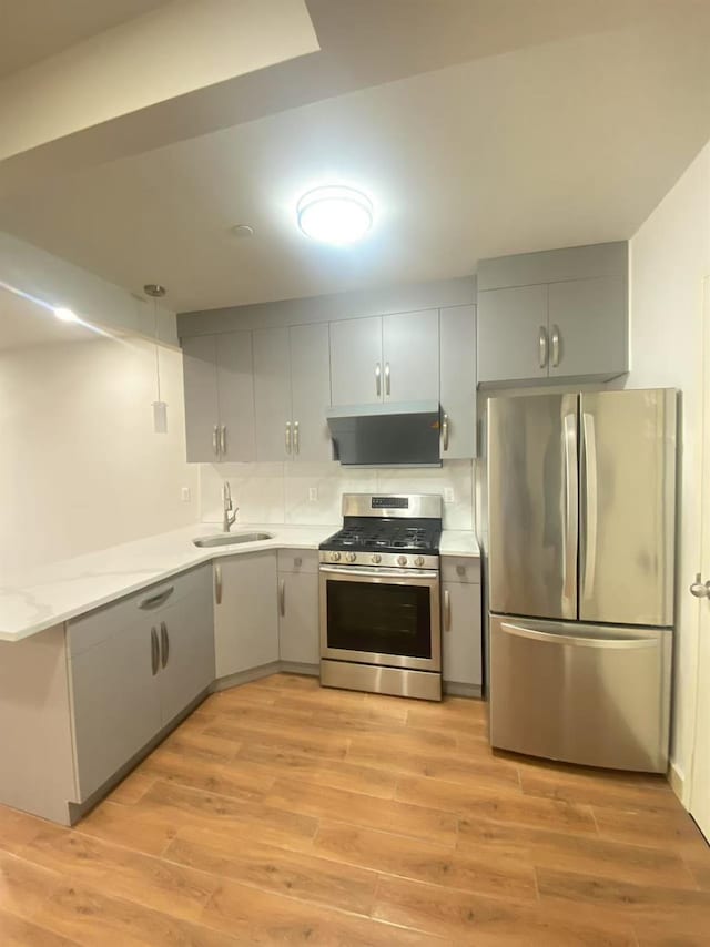 42-22 Crescent St Unit 3B, Long Island City, NY 11101 - kitchen featuring appliances with stainless steel finishes, light countertops, light wood-style flooring, exhaust hood, and a peninsula