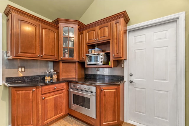 1 Willits Rd, Glen Cove, NY 11542 - kitchen featuring oven, glass insert cabinets, dark stone countertops, and brown cabinetry