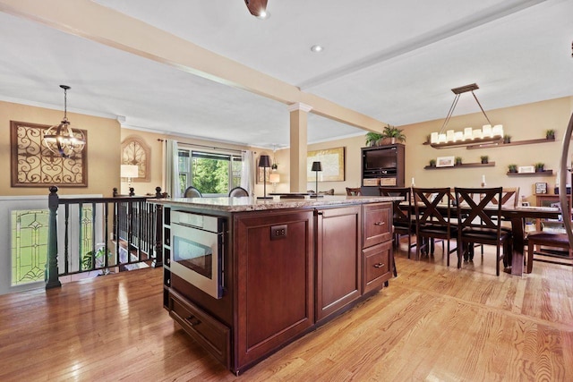 39 Bykenhulle Rd, Hopewell Junction, NY 12533 - kitchen featuring light wood-type flooring, pendant lighting, stainless steel microwave, a kitchen island with sink, and ornamental molding