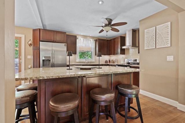 39 Bykenhulle Rd, Hopewell Junction, NY 12533 - kitchen featuring stainless steel appliances, wall chimney exhaust hood, a ceiling fan, backsplash, and light stone countertops