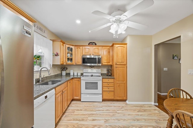 273 N Brewster Rd, Brewster, NY 10509 - kitchen with stainless steel appliances, dark stone counters, glass insert cabinets, light wood-type flooring, and a ceiling fan