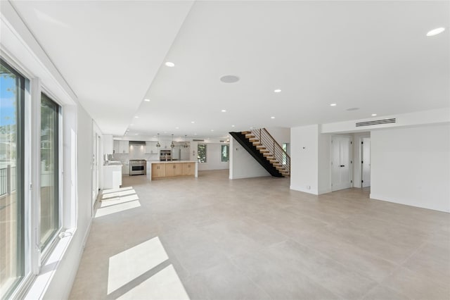 141 Flamingo St, Atlantic Beach, NY 11509 - unfurnished living room with plenty of natural light, stairs, and recessed lighting