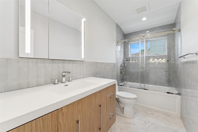 141 Flamingo St, Atlantic Beach, NY 11509 - full bathroom featuring tile walls, combined bath / shower with glass door, vanity, marble look tiles, and a wainscoted wall