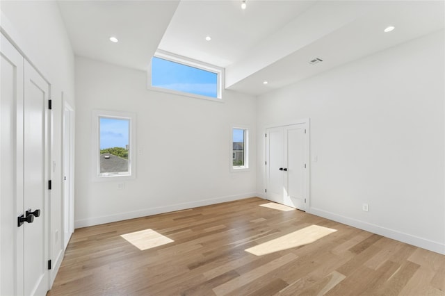 141 Flamingo St, Atlantic Beach, NY 11509 - unfurnished bedroom with a towering ceiling, light wood-style floors, and recessed lighting