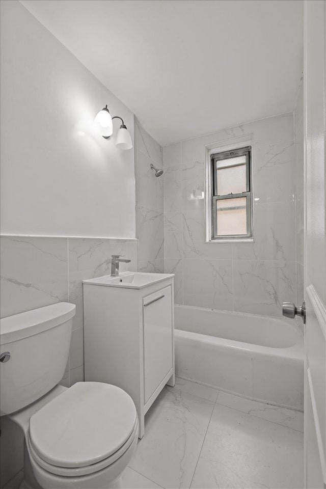 2107 Wallace Ave Unit 4G, Bronx, NY 10462 - bathroom featuring marble look tiles, vanity, tub / shower combination, a wainscoted wall, and tile walls