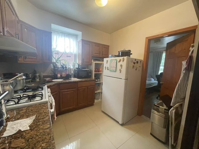20-39 150th St, Whitestone, NY 11357 - kitchen with freestanding refrigerator, black microwave, under cabinet range hood, light tile patterned floors, and healthy amount of natural light