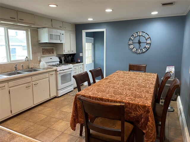 39 Herbert Ave, Lindenhurst, NY 11757 - kitchen with white appliances, tasteful backsplash, white cabinets, a baseboard heating unit, and crown molding