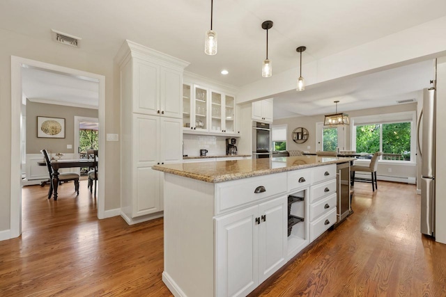 9 Carol Ct, Brewster, NY 10509 - kitchen with beverage cooler, a kitchen island, freestanding refrigerator, plenty of natural light, and recessed lighting